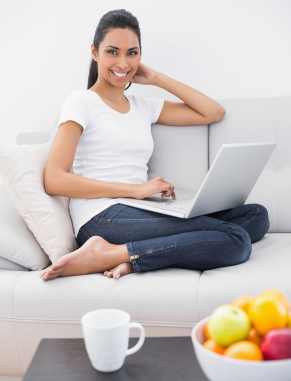 Tarifs des consultations jeune femme souriante assise sur son canapé