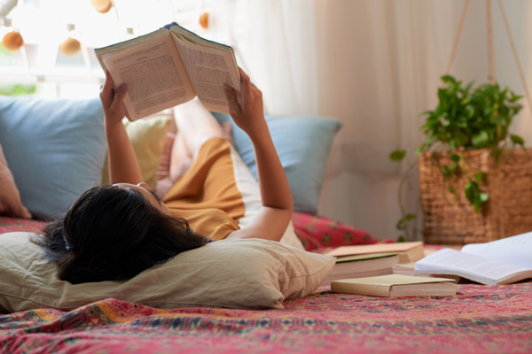 Femme avec des livres sur son lit à propos la nutrition